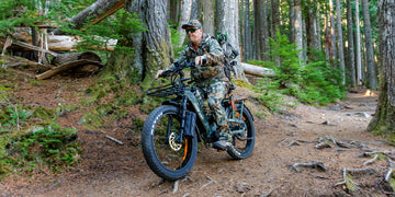 A bowhunter navigating a rugged forest trail on the Himiway D5 2.0 camo fat tire electric bike.
