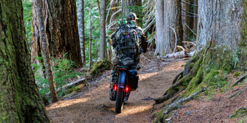 A camo-clad hunter riding his loaded Himiway D5 2.0 camo fat tire electric bike deep into an old-growth forest trail.