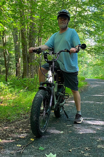 Person riding an himiway D5 2.0 st electric bike near a lake with a clear blue sky.